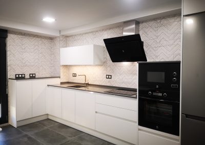 Cocina moderna blanca con electrodomésticos negros