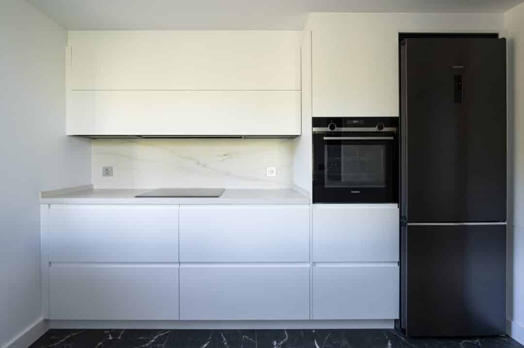 Cocina moderna blanca con electrodomésticos negros