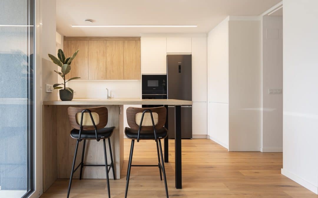 Cocina en blanco y madera abierta al salón